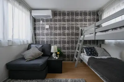 a small room with a bunk bed and a couch at Skytree View Riverside Terrace in Tokyo