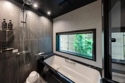 a bathroom with a bath tub and a window at HoursHouse HD JAPAN in Tokyo