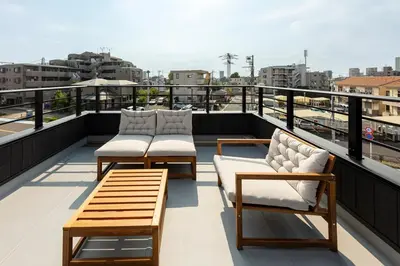 a balcony with chairs and tables on a roof at HoursHouse HD JAPAN in Tokyo