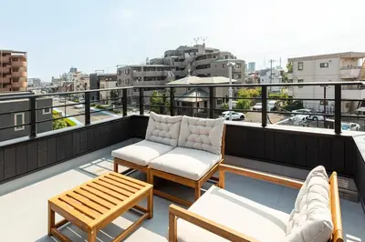 a balcony with a couch and chairs on a roof at HoursHouse HD JAPAN in Tokyo