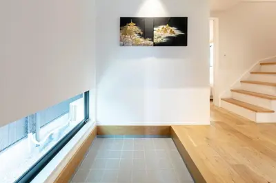 a living room with stairs and a painting on the wall at HoursHouse HD JAPAN in Tokyo