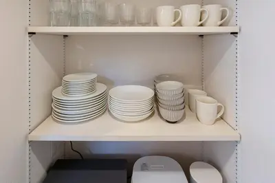 a shelf full of plates and cups and bowls at HoursHouse HD JAPAN in Tokyo