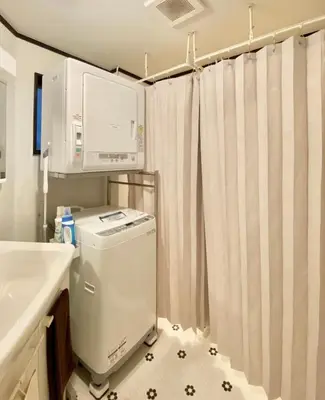 a bathroom with a sink and a washer and dryer at INDIGO HOUSE 3-story House, 4BR 8 Beds, Family Friends Welcome - Shinjuku Disney\u6771\u4eac\u30c7\u30a3\u30ba\u30cb\u30fc\u30ea\u30be\u30fc\u30c8 in Tokyo