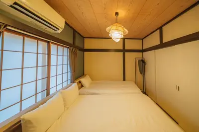 a bedroom with a large bed in a room with windows at INDIGO HOUSE 3-story House, 4BR 8 Beds, Family Friends Welcome - Shinjuku Disney\u6771\u4eac\u30c7\u30a3\u30ba\u30cb\u30fc\u30ea\u30be\u30fc\u30c8 in Tokyo