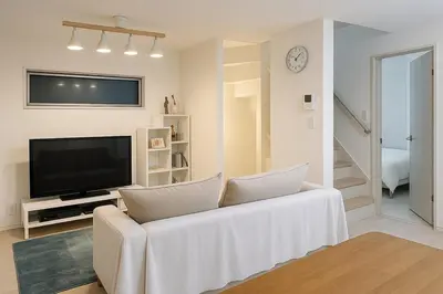 a living room with a white couch and a television at Private Yotsugi Prime Direct Access from Haneda & Narita Airports in Tokyo