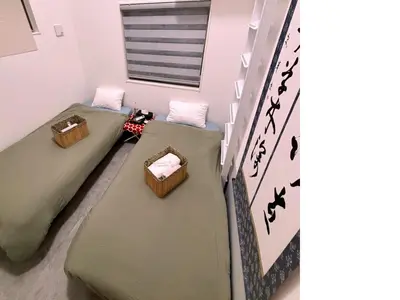 two beds in a room with asian writing on the wall at Private Yotsugi Prime Direct Access from Haneda & Narita Airports in Tokyo