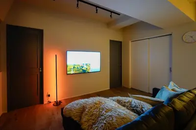 a living room with a couch and a flat screen tv at SATELLITE HOTEL Higashiazabu \u30b5\u30c6\u30e9\u30a4\u30c8\u30db\u30c6\u30eb\u6771\u9ebb\u5e03 in Tokyo