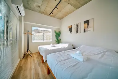 a bedroom with two beds and a window at SATELLITE HOTEL Higashiazabu \u30b5\u30c6\u30e9\u30a4\u30c8\u30db\u30c6\u30eb\u6771\u9ebb\u5e03 in Tokyo