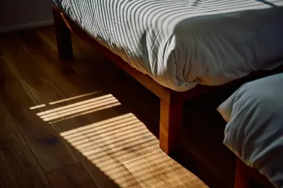 a bed sitting on top of a wooden floor at SATELLITE HOTEL Higashiazabu \u30b5\u30c6\u30e9\u30a4\u30c8\u30db\u30c6\u30eb\u6771\u9ebb\u5e03 in Tokyo