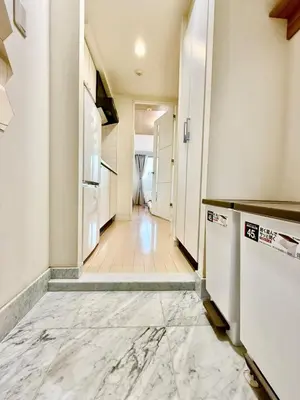 a hallway with a kitchen with white walls and marble floors at Room with a view of Skytree, close to Kinshicho station in Tokyo