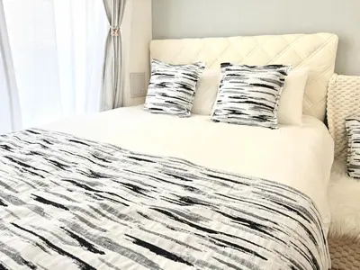 a bed with black and white sheets and pillows at Room with a view of Skytree, close to Kinshicho station in Tokyo