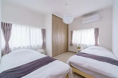 a bedroom with two beds and a chandelier at Tany House 1F sky tree 20 minutes, maximum 8 people, 3 bedrooms, new interior in Tokyo