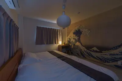 a bedroom with a bed with a painting of a wave at Tany House 1F sky tree 20 minutes, maximum 8 people, 3 bedrooms, new interior in Tokyo