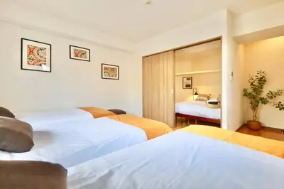 a hotel room with three beds and a bedroom at \u30b9\u30ab\u30a4\u30c4\u30ea\u30fc\u30d3\u30e5\u30fc \u6700\u592711\u540d \u9ad8\u7d1a\u30de\u30f3\u30b7\u30e7\u30f3\u6700\u4e0a\u968e \u30bd\u30ec\u30a4\u30e6501 in Tokyo