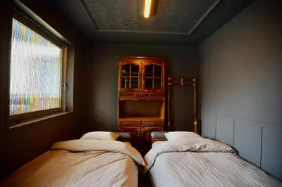 two beds in a room with a cabinet and a window at MUSICIAN AIR 0014 kyojima in Tokyo