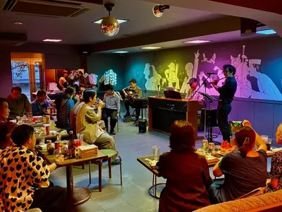 a group of people sitting around a room with a man on a stage at MUSICIAN AIR 0014 kyojima in Tokyo
