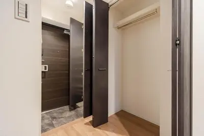 a walk in closet with a black door and white walls at konomi \u4e8c\u5341\u4e8c\u756a\u9928 \u83ca\u5ddd\u5f92\u6b693\u5206 in Tokyo