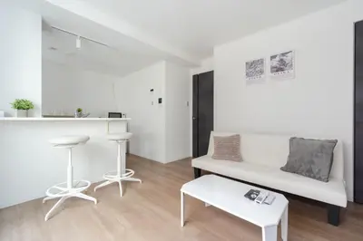 a white living room with a white couch and a stool at konomi \u4e8c\u5341\u4e8c\u756a\u9928 \u83ca\u5ddd\u5f92\u6b693\u5206 in Tokyo