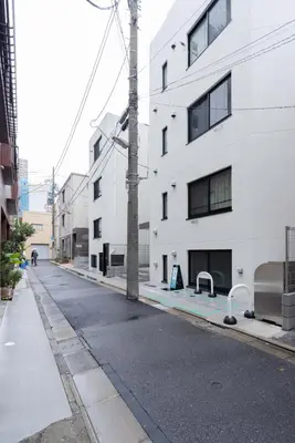 an empty street next to a white building at konomi \u4e8c\u5341\u4e8c\u756a\u9928 \u83ca\u5ddd\u5f92\u6b693\u5206 in Tokyo