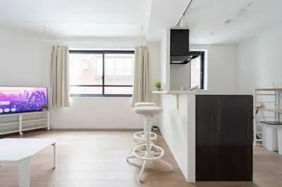 a living room with a bar stool and a tv at konomi \u4e8c\u5341\u4e8c\u756a\u9928 \u83ca\u5ddd\u5f92\u6b693\u5206 in Tokyo