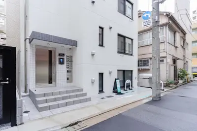 a white building on a city street at konomi \u4e8c\u5341\u4e8c\u756a\u9928 \u83ca\u5ddd\u5f92\u6b693\u5206 in Tokyo