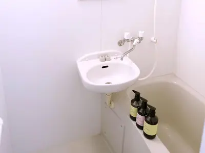 a white bathroom with a sink and a bath tub at Near Asakusa, Projector, Twin and Semi Double Rooms in Tokyo