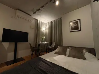 a bedroom with a bed and a table with chairs at FARE Akihabara - Stylish Premium Studio 8min from Station 202 in Tokyo