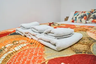 a pile of towels sitting on top of a bed at Serendipity Asakusa in Tokyo