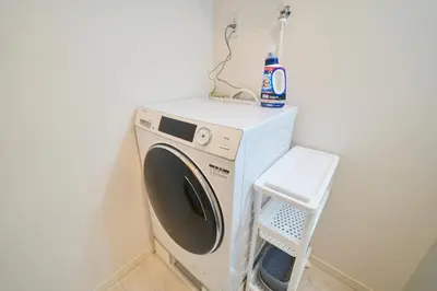 a washer and dryer in a corner of a room at Serendipity Asakusa in Tokyo