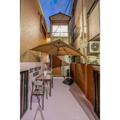 a patio with a table and chairs and an umbrella at Sky Tree Stay Hotel 5 8-minute walk from Yahiro Station 3-minute train ride to Tokyo Skytree Station in Tokyo