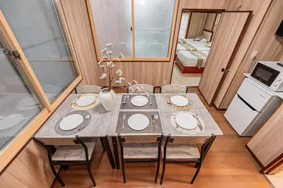 a dining room with a table and chairs and a kitchen at Sky Tree Stay Hotel 5 8-minute walk from Yahiro Station 3-minute train ride to Tokyo Skytree Station in Tokyo