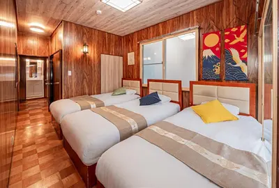 a group of four beds in a room with wooden walls at Sky Tree Stay Hotel 5 8-minute walk from Yahiro Station 3-minute train ride to Tokyo Skytree Station in Tokyo