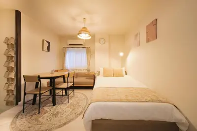 a bedroom with two beds and a table and a couch at MIKASA guesthouse3 in Tokyo