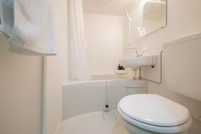 a white bathroom with a toilet and a sink at MIKASA guesthouse3 in Tokyo