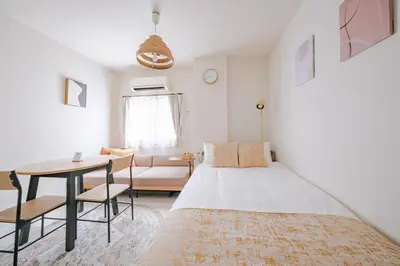 a bedroom with a bed and a table and a couch at MIKASA guesthouse3 in Tokyo