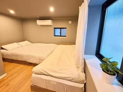 a small bedroom with two beds and a window at \u6e0b\u8c37\u611b\u306e\u6cca in Tokyo