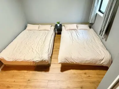 two beds in a small room with wooden floors at \u6e0b\u8c37\u611b\u306e\u6cca in Tokyo