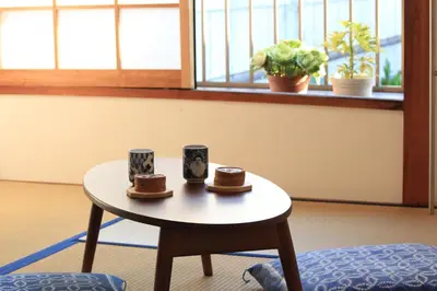 a table with two hats and two cups on it at Hostel Hana An in Tokyo
