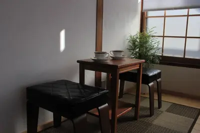 a small table and two chairs and a table and stool at Hostel Hana An in Tokyo