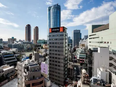 a tall building with a sign on it in a city at APA Hotel Roppongi Ekimae in Tokyo
