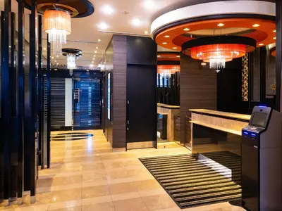 a hotel lobby with a bar and chandeliers at APA Hotel Roppongi Ekimae in Tokyo