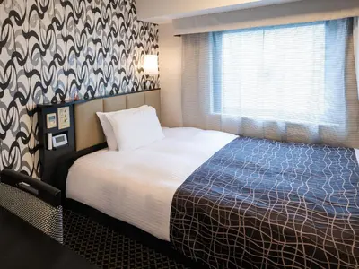 a hotel room with a bed and a window at APA Hotel Roppongi Ekimae in Tokyo