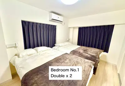 a bedroom with two beds and a sign that reads bathroom noiuses at Shimbashi,3BR,2Baths,8ppl in Tokyo