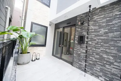 a brick wall with a potted plant on a balcony at Home Story in Tokyo Aerial大島&東京屋 in Tokyo
