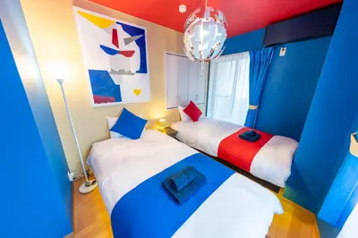 two beds in a room with blue and red at Ikebukuro the Anime Mecca NEO TOKYO BASE Fortuna House in Tokyo