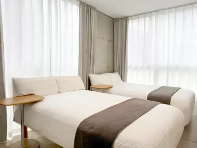 two beds in a hotel room with a window at 101Room,7-minute walk from Uguisudani Station located on the 1nd floor of an apartment-style building Twin room No elevator in Tokyo