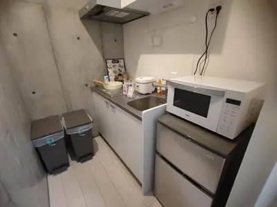 a small kitchen with a sink and a microwave at 101Room,7-minute walk from Uguisudani Station located on the 1nd floor of an apartment-style building Twin room No elevator in Tokyo