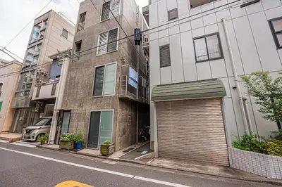 an apartment building with a garage on a city street at Ginza Stay Tsukishima Station 1-minute walk, Ginza, Shinjuku, Tsukiji Market tram direct, supermarket, next to the canal, Tokyo Bay stroll in Tokyo