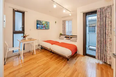 a bedroom with a bed and a desk and a window at Skytree Stay Home, a 4-minute walk from Oshiage Station, a private house with an elevator in Tokyo
