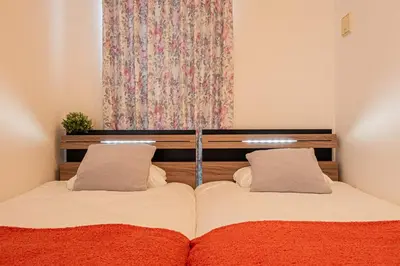 a bedroom with a bed with two pillows on it at Skytree Stay Home, a 4-minute walk from Oshiage Station, a private house with an elevator in Tokyo